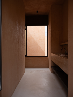 Bathroom with a long trough sink and a tall window above a built-in window seat