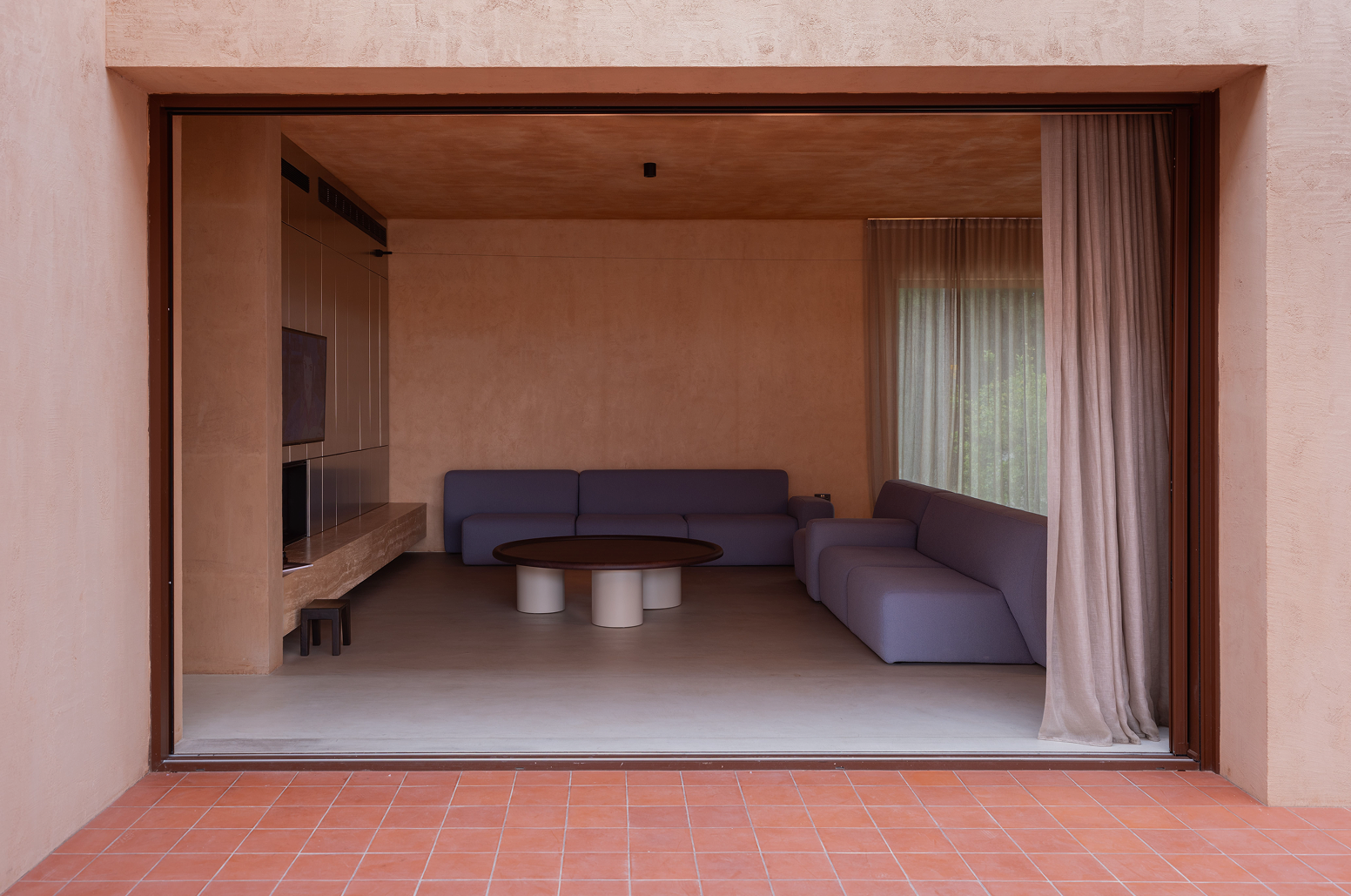 View from the tiled veranda into the living room through a wide framed opening